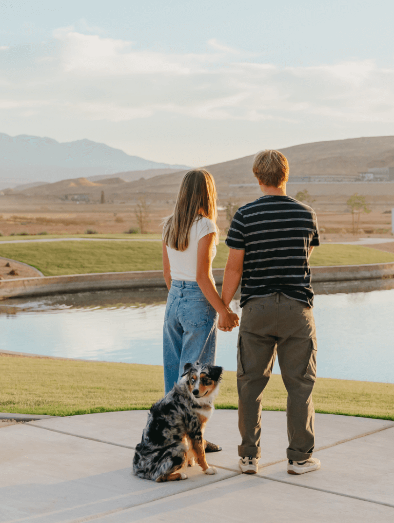 couple overlooking a pond with dog