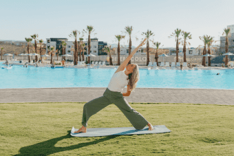 woman doing yoga by a desert color pool