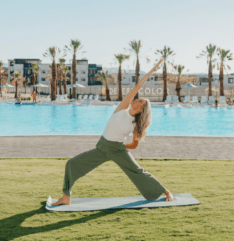 woman doing yoga by a desert color pool
